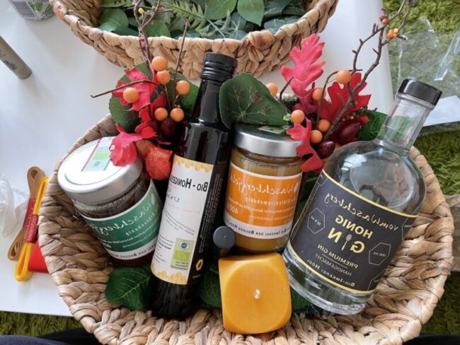 Geschenkkorb mit Pordukten wie Honig, Honig-Gin, Bienenwachskerze und Biohonigessig